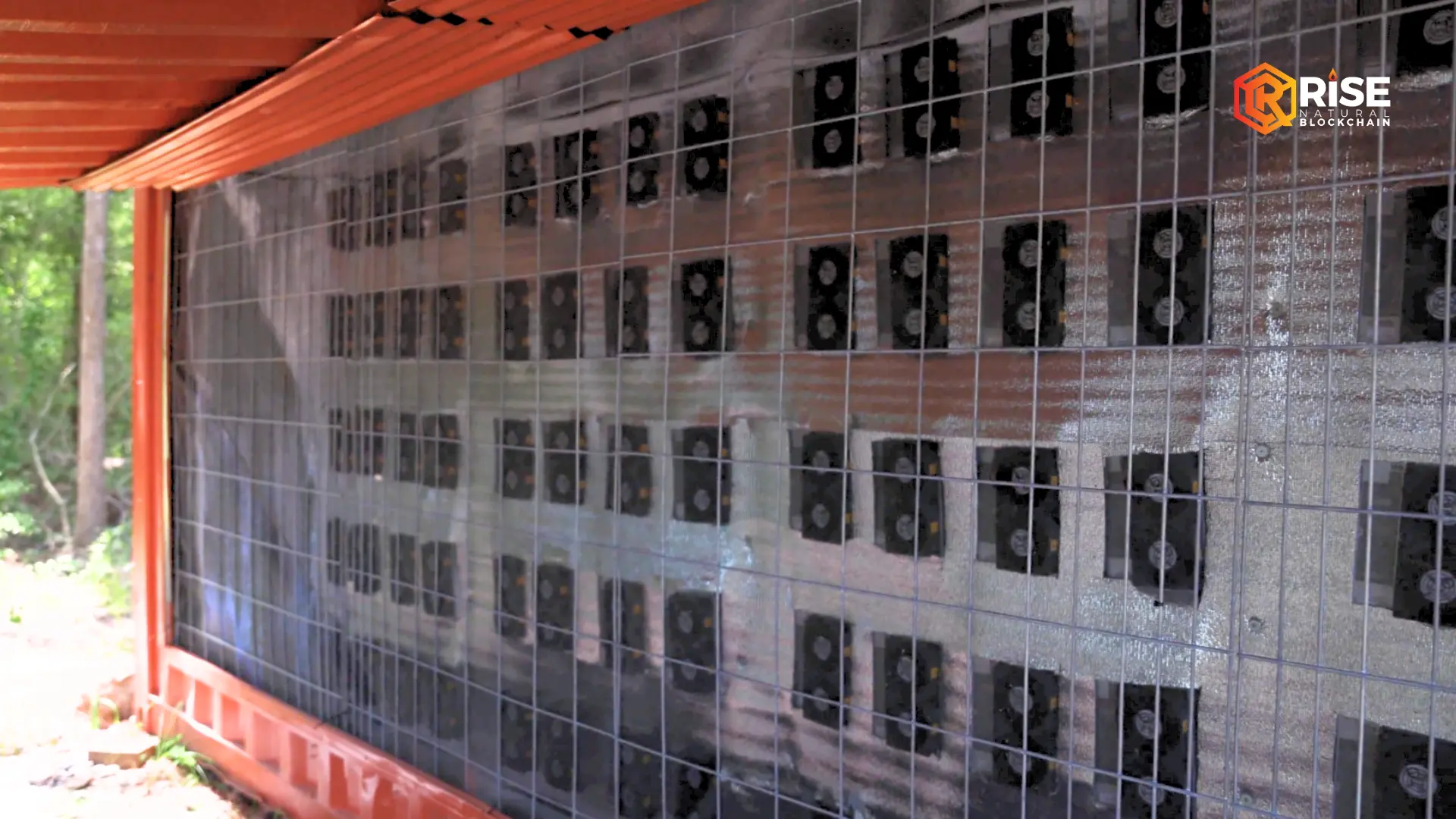 Exterior wall of a Rise Natural Blockchain mining container with rows of miner exhaust fans