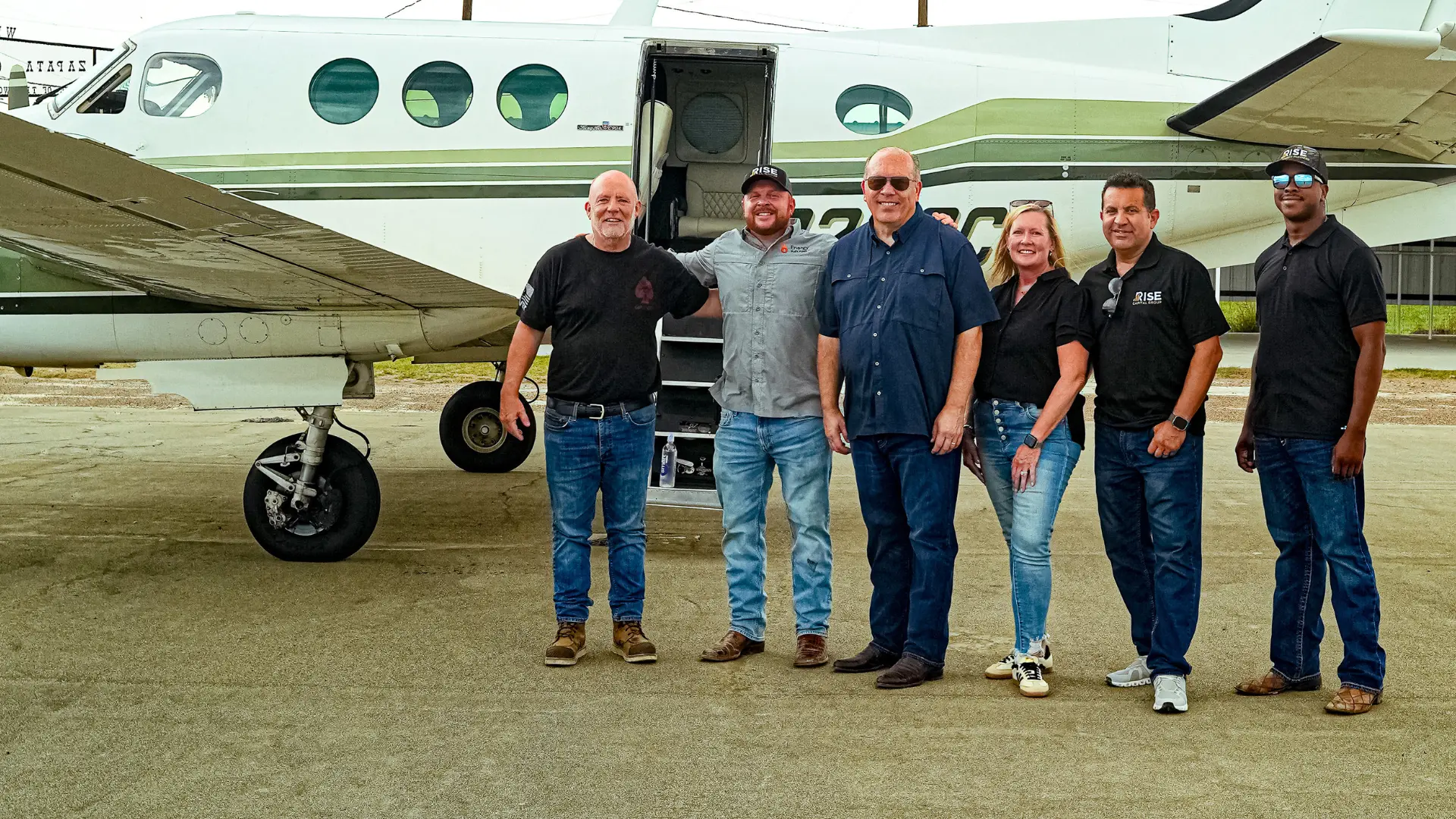 Rise Capital Group team standing in front of an aircraft